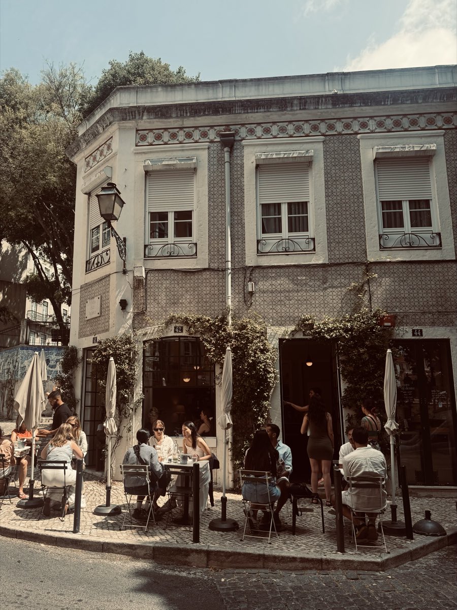 De hoekgevel van Magnólia met azulejos, klimplanten en een vol terras