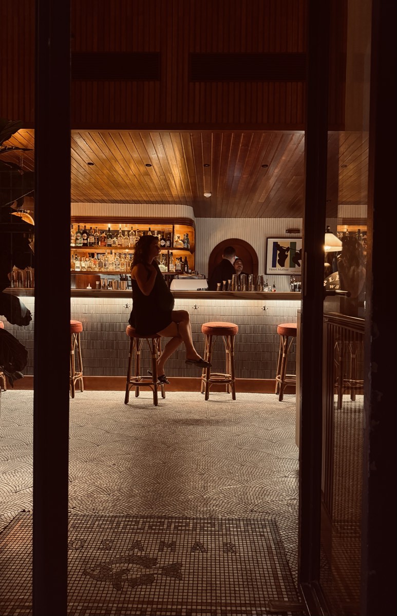 De bar van Rosamar met rotan barkrukken, gezien vanaf de mozaïekvloer met vissen