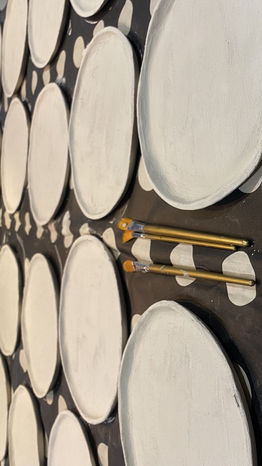 Een tafel vol handgemaakte borden met penselen ertussen