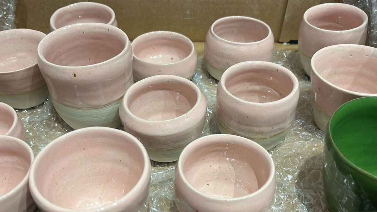 Een doos vol roze geglazuurde kopjes en één groene